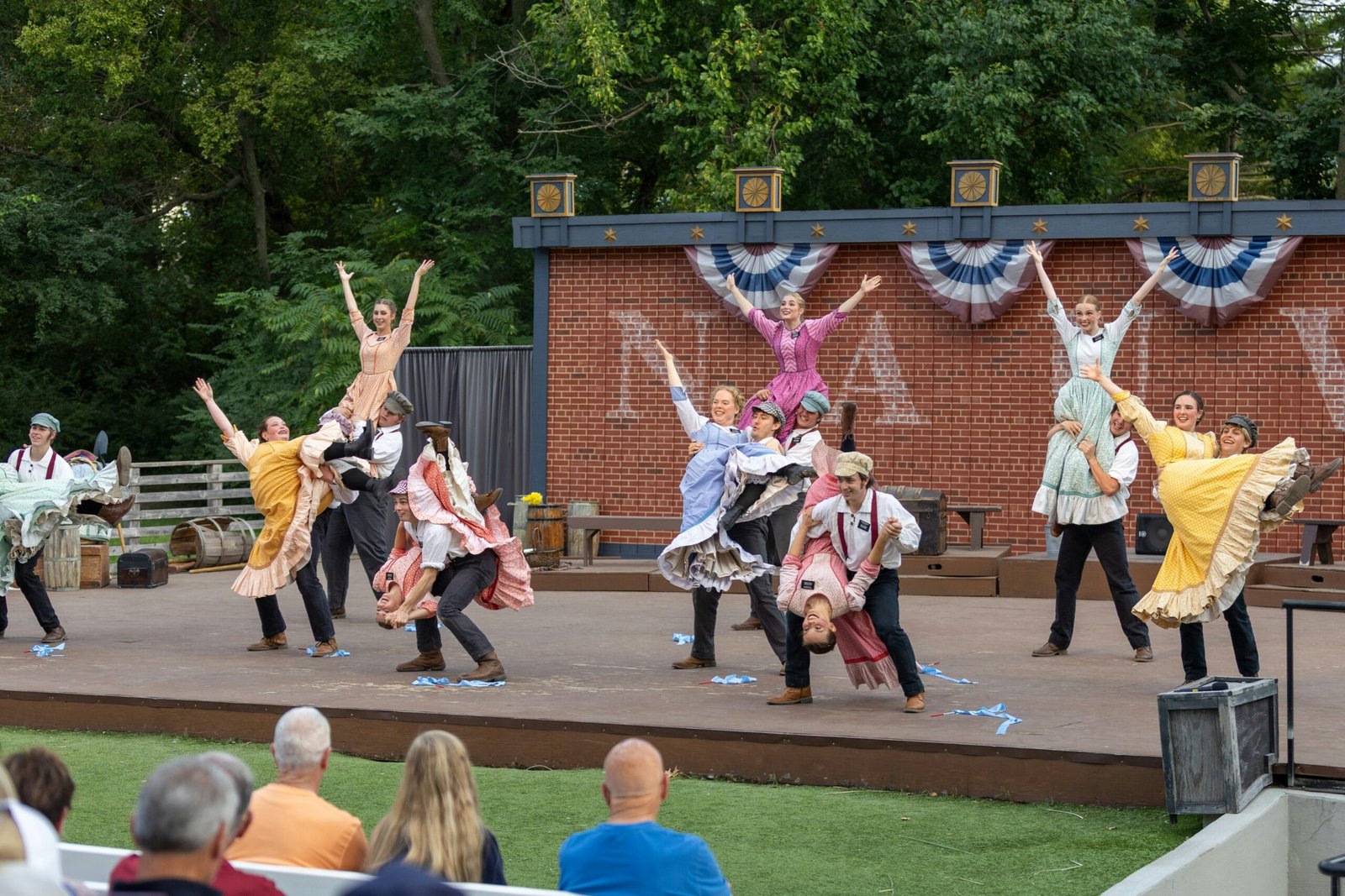 Performers on an outdoor stage before an evening audience