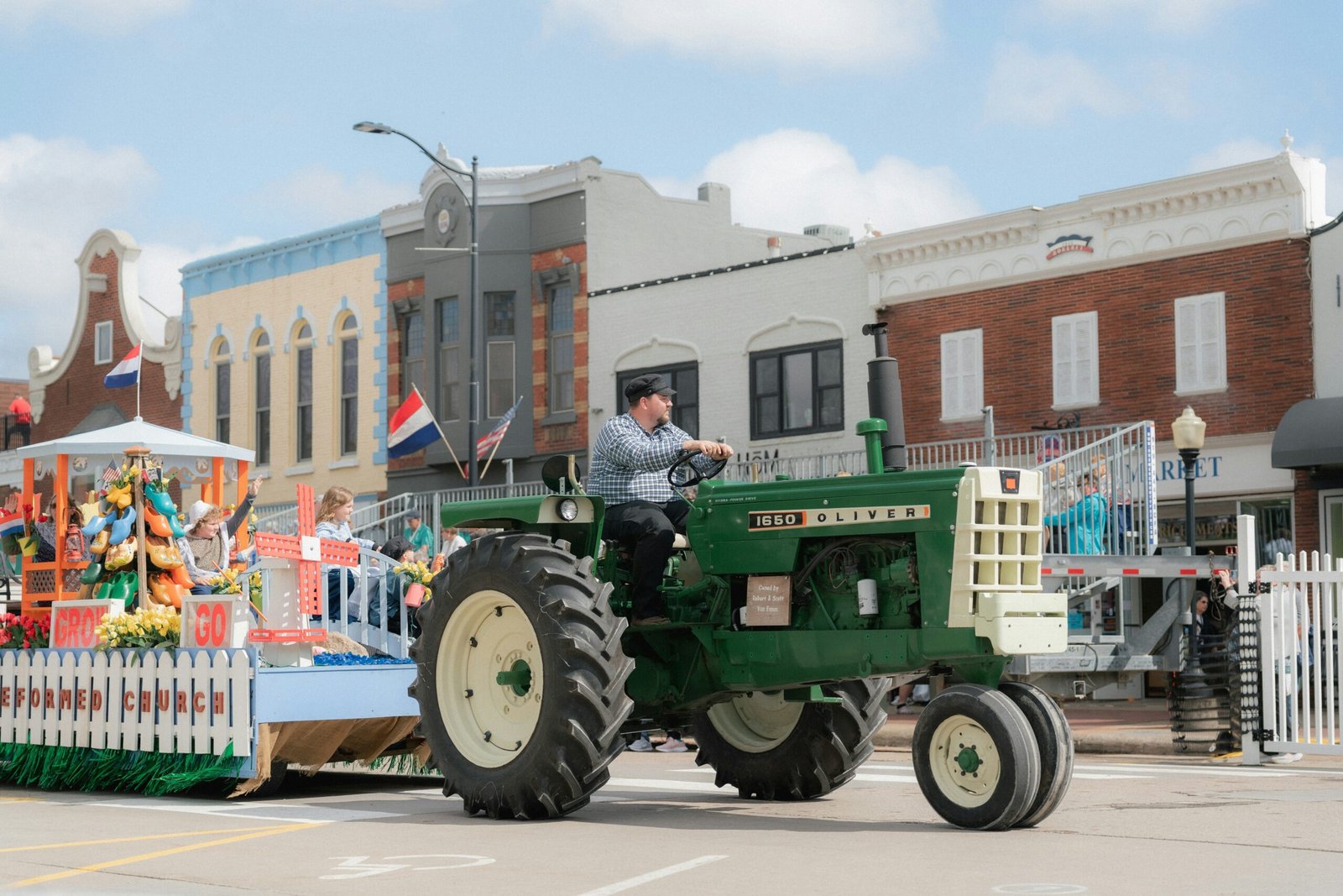 Tractor pulling a parade float down a small-town street